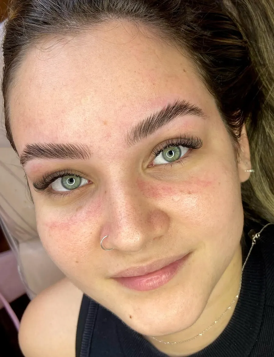 Cliente de olhos verdes com sobrancelhas alinhadas e extensão de cílios